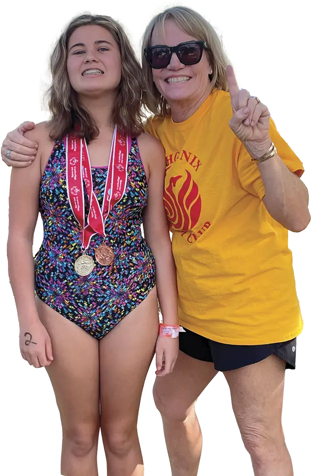 girl with medals smiling with her mom holding up a peace sign