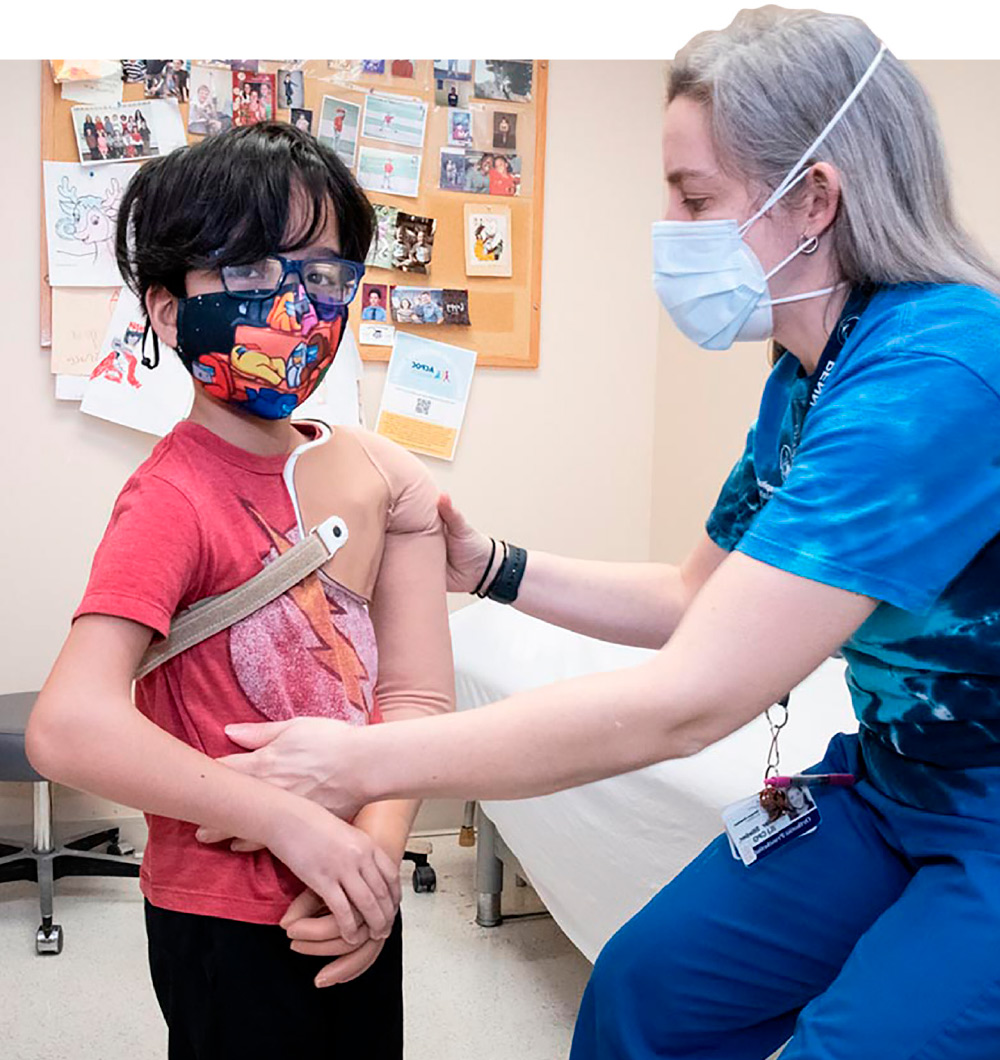 nurse helping young boy with prosthetic