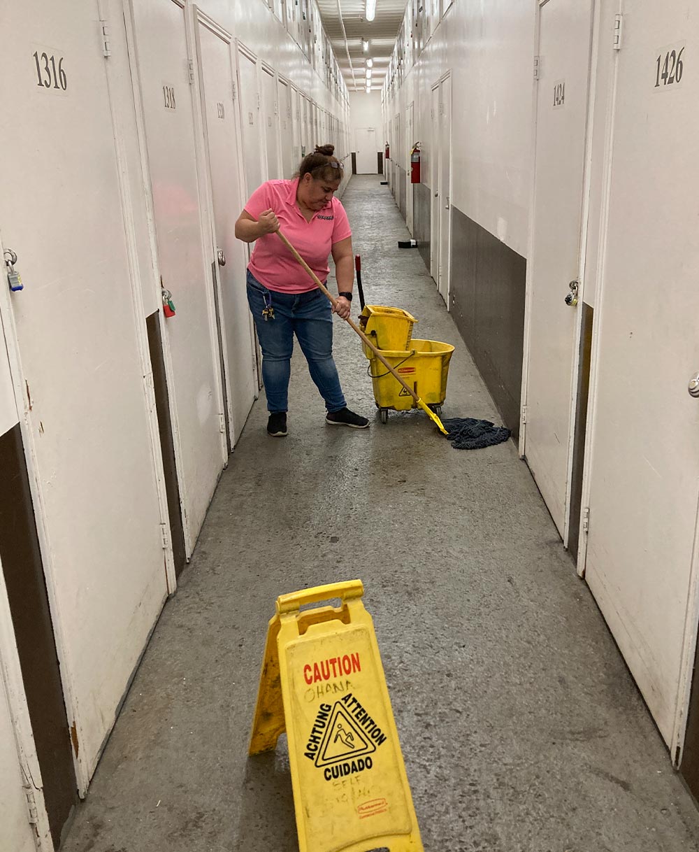 Jenny Rodrigues mops a long hallway in the Ohana storage facility