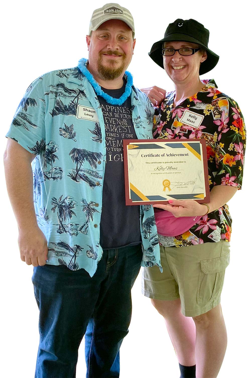 Portrait photograph of Shawn Lewy & Kelly Maas smiling next to each other as Kelly Maas holds a 2023 Certificate of Achievement award in her left hand with both of them dressed up in a Hawaiian-style attire