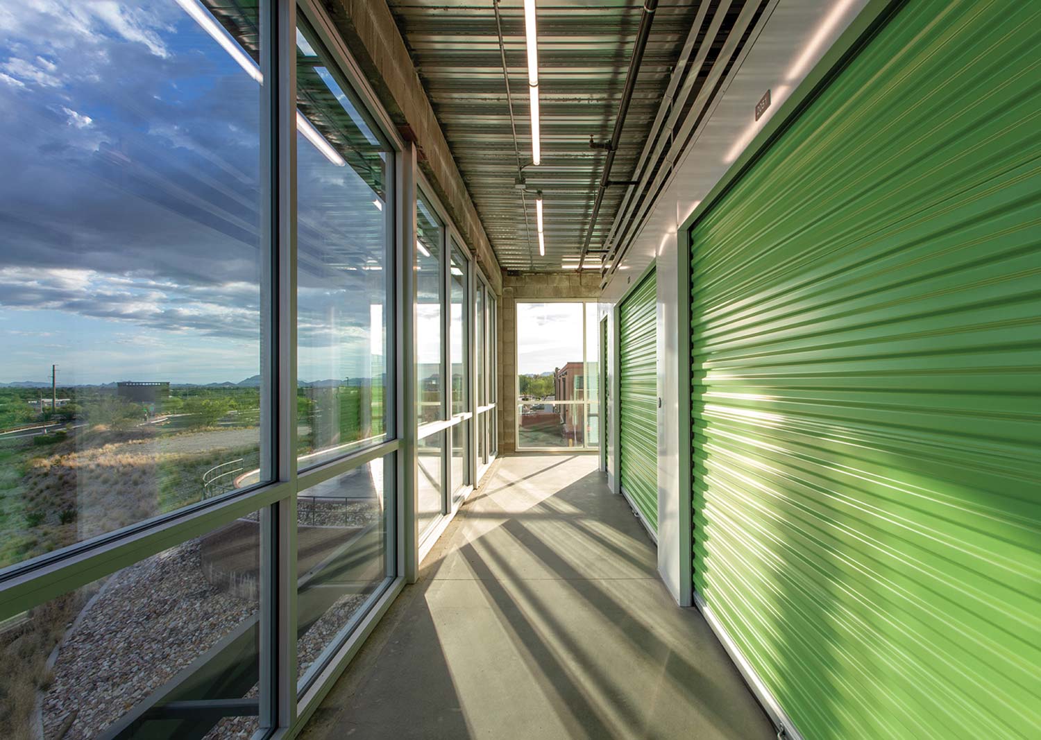 hallway of a storage facility with green doors