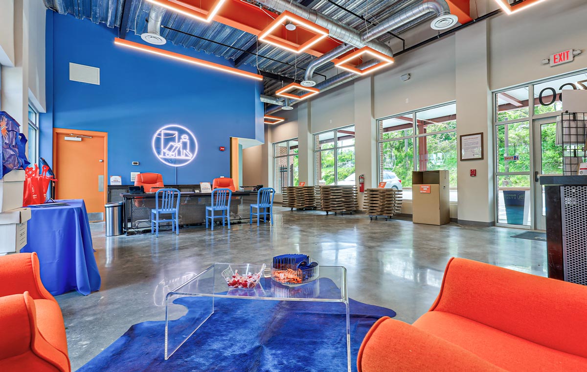 corner view of the spacious Morningstar Storage lobby designed with a deep blue and vibrant orange color scheme