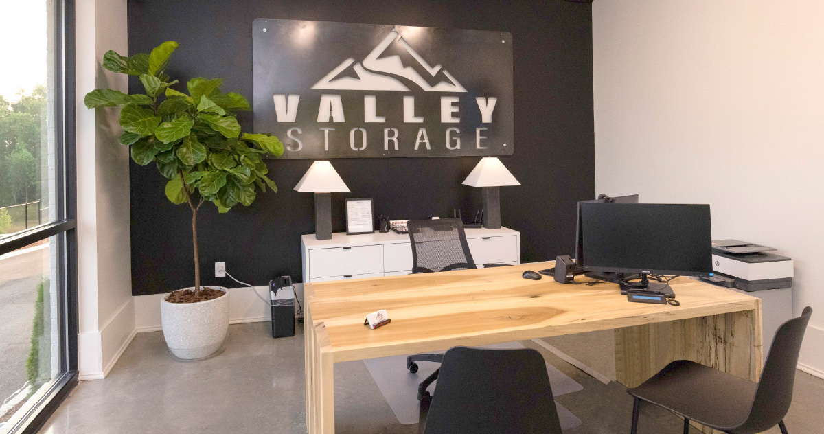 Valley Storage office with metal logo sign hung behind