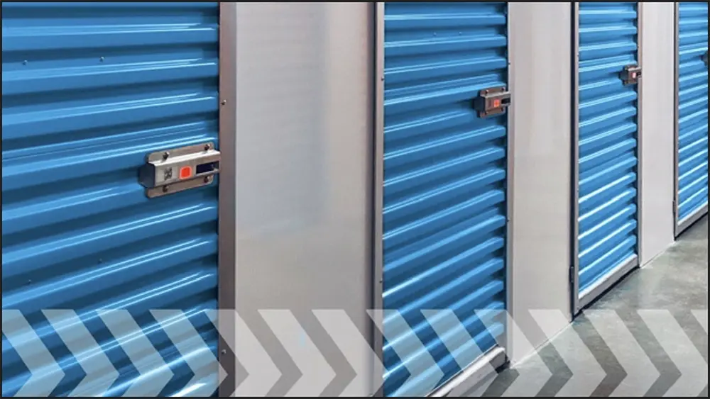 Close-up view of four blue self-storage units all securely locked with a red light indicator on the actual metal rectangular lock