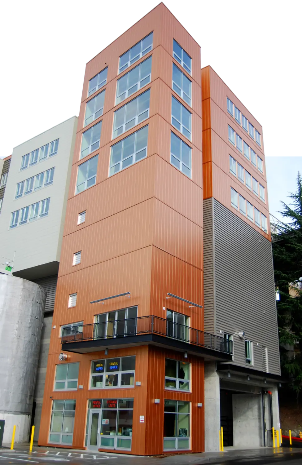 street view upward of a tall multi-storied storage facility with an orange and gray blocked façade