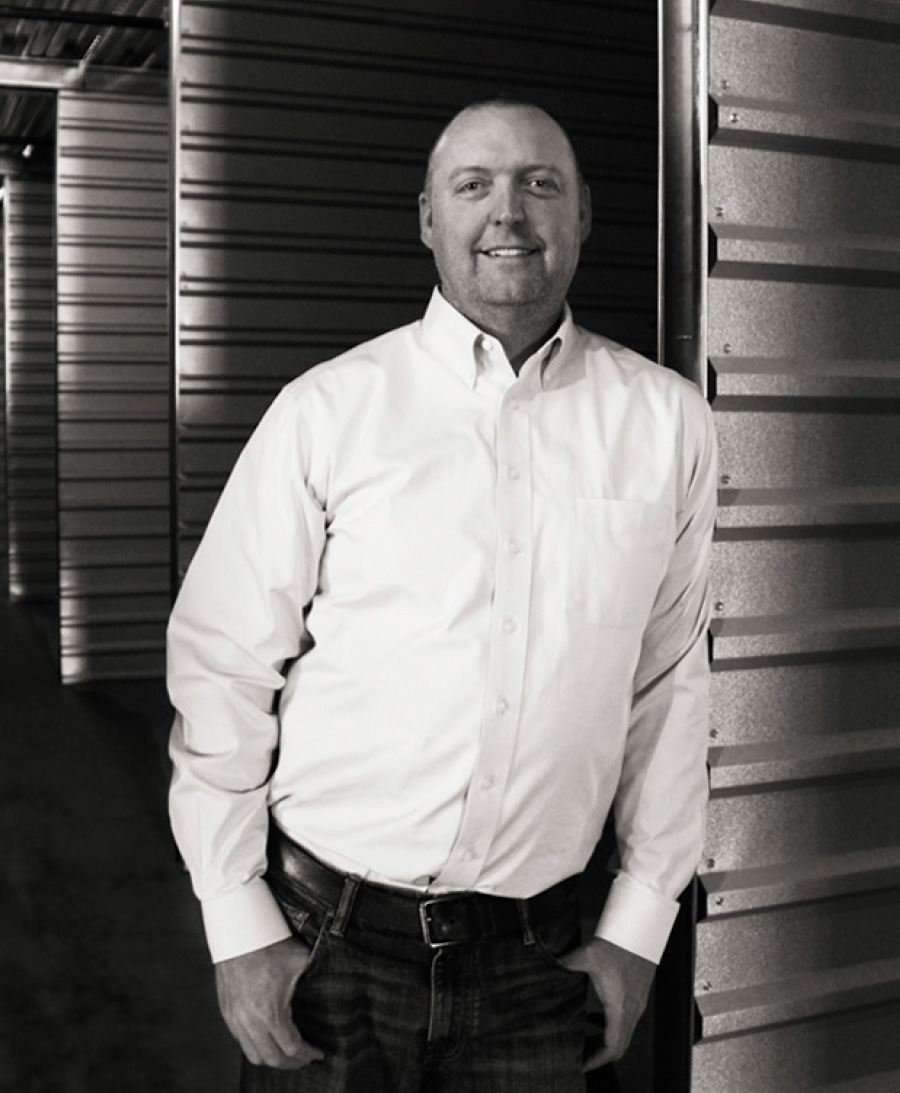 Curtis Ryan leaning against metal door with hands in pockets