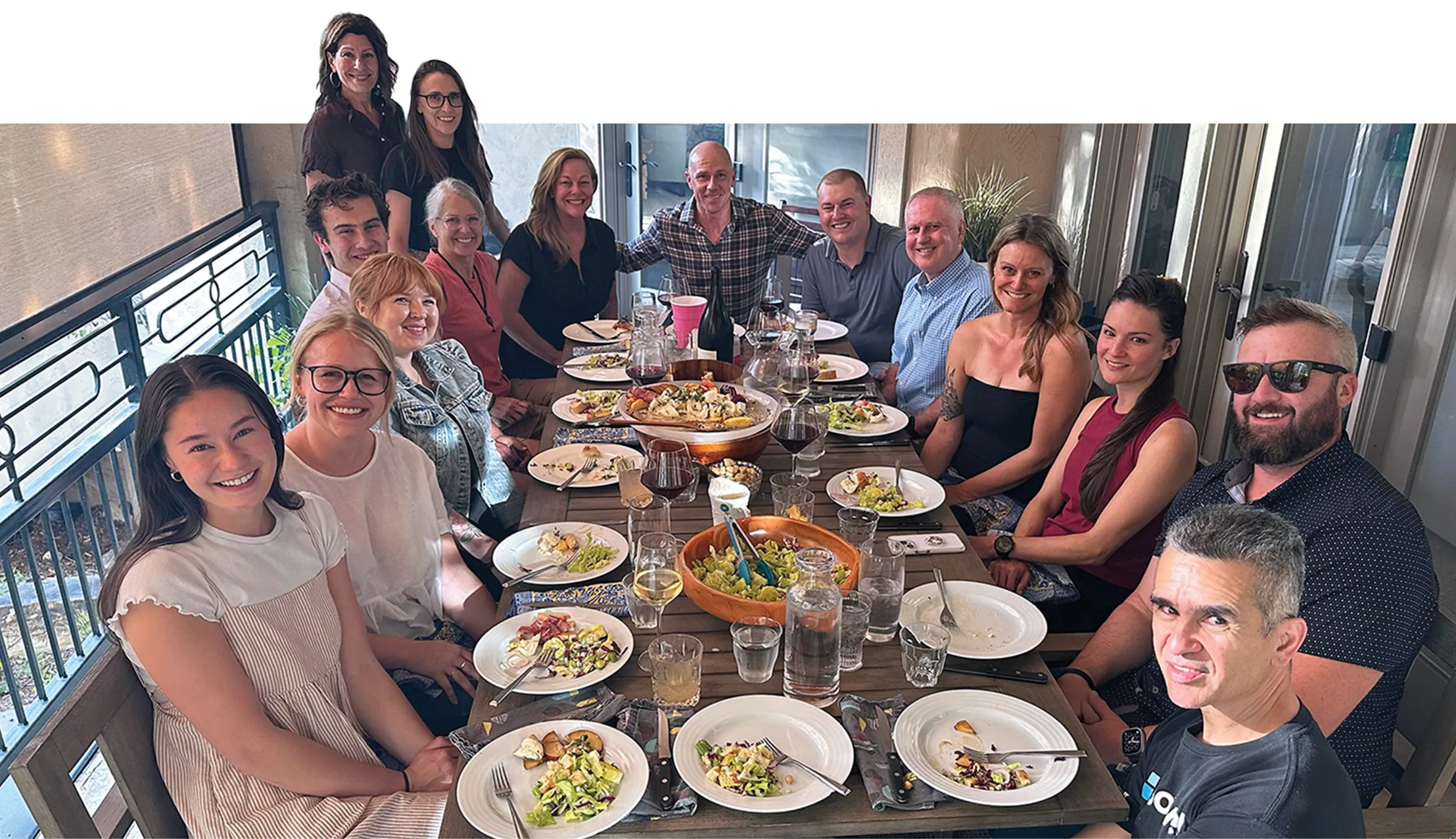 family smiling sitting around a large dinner table