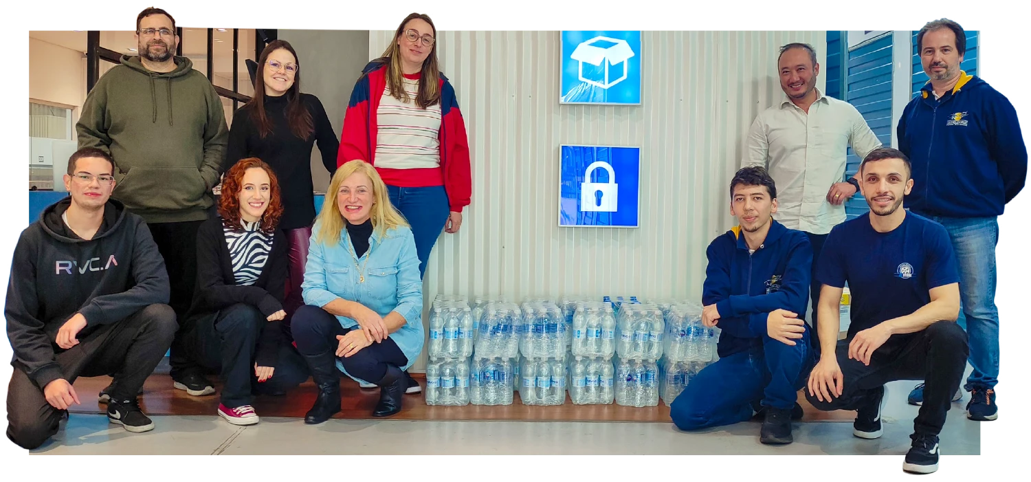 A group photo of people smiling with multiple cases of water bottles in between them