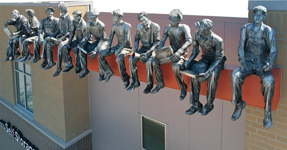 statue depicting old skyscraper construction workers