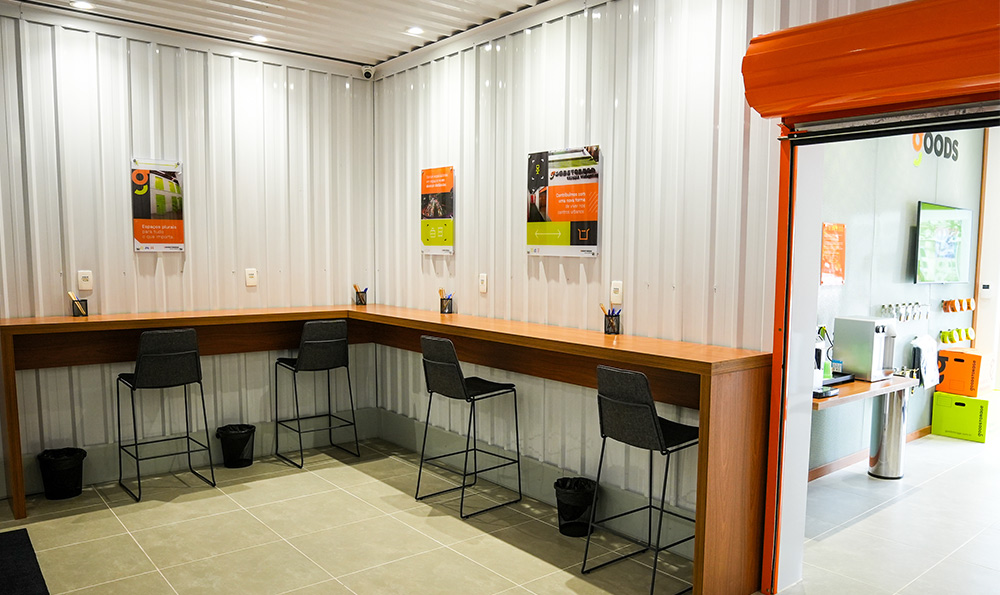 quarter view of an outdoor garage storage structure with vibrant orange roll up doors