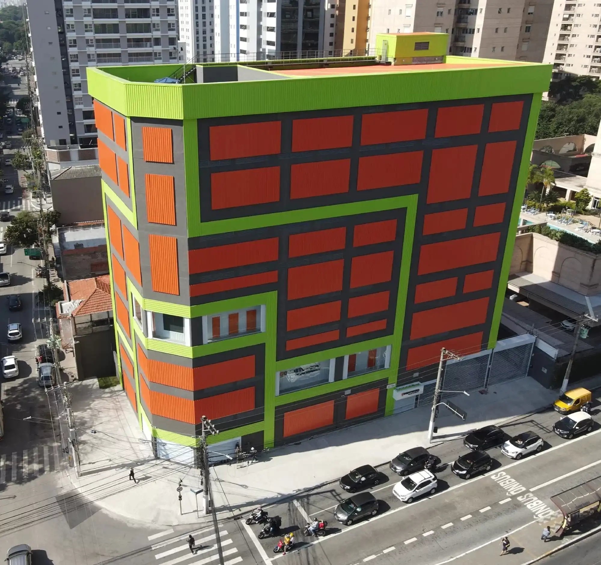 high drone view of the Good Storage, a tall vibrant orange and green facility in Latin America