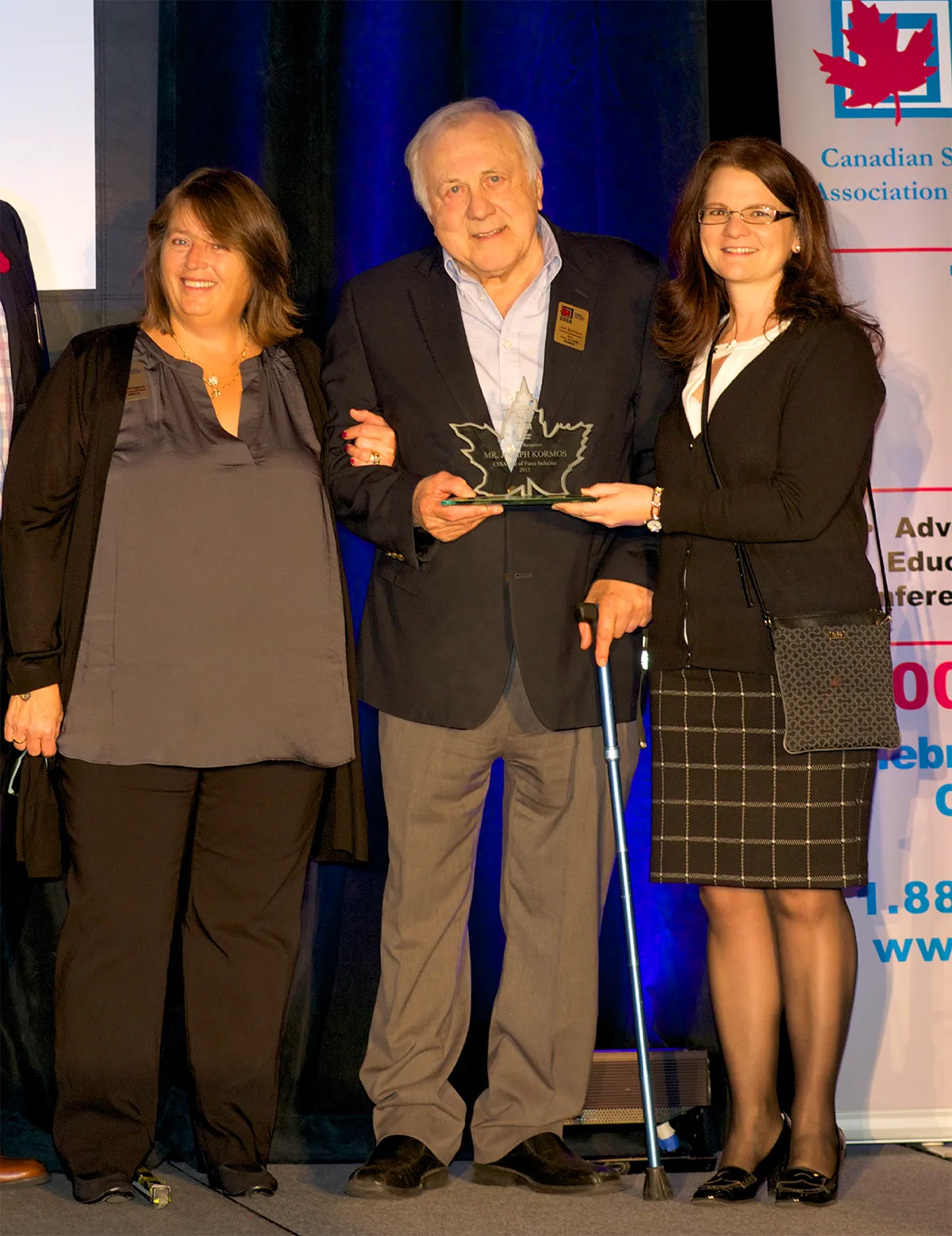 man on stage accepting an award at a Canadian storage event
