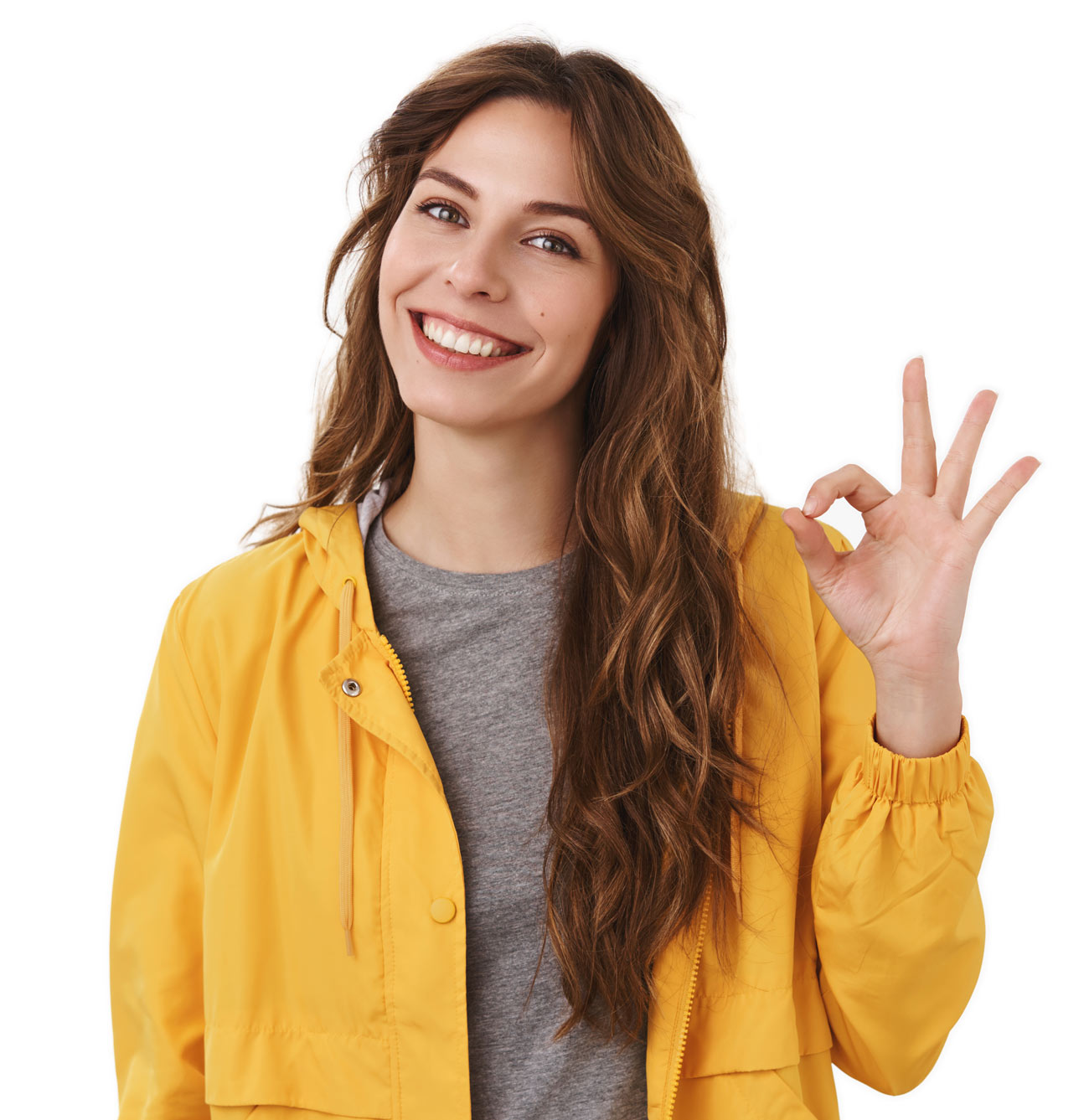 smiling woman wearing a yellow jacket holding up her hand and making an 'okay' gesture