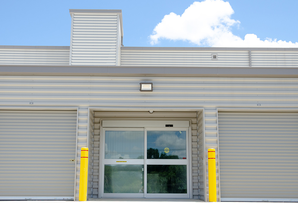 front view of a large corrugated metal structure with rolling storage unit doors