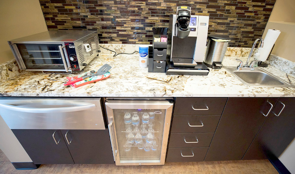 full view of a coffee bar with water bottle cooler and toaster oven for baking cookies