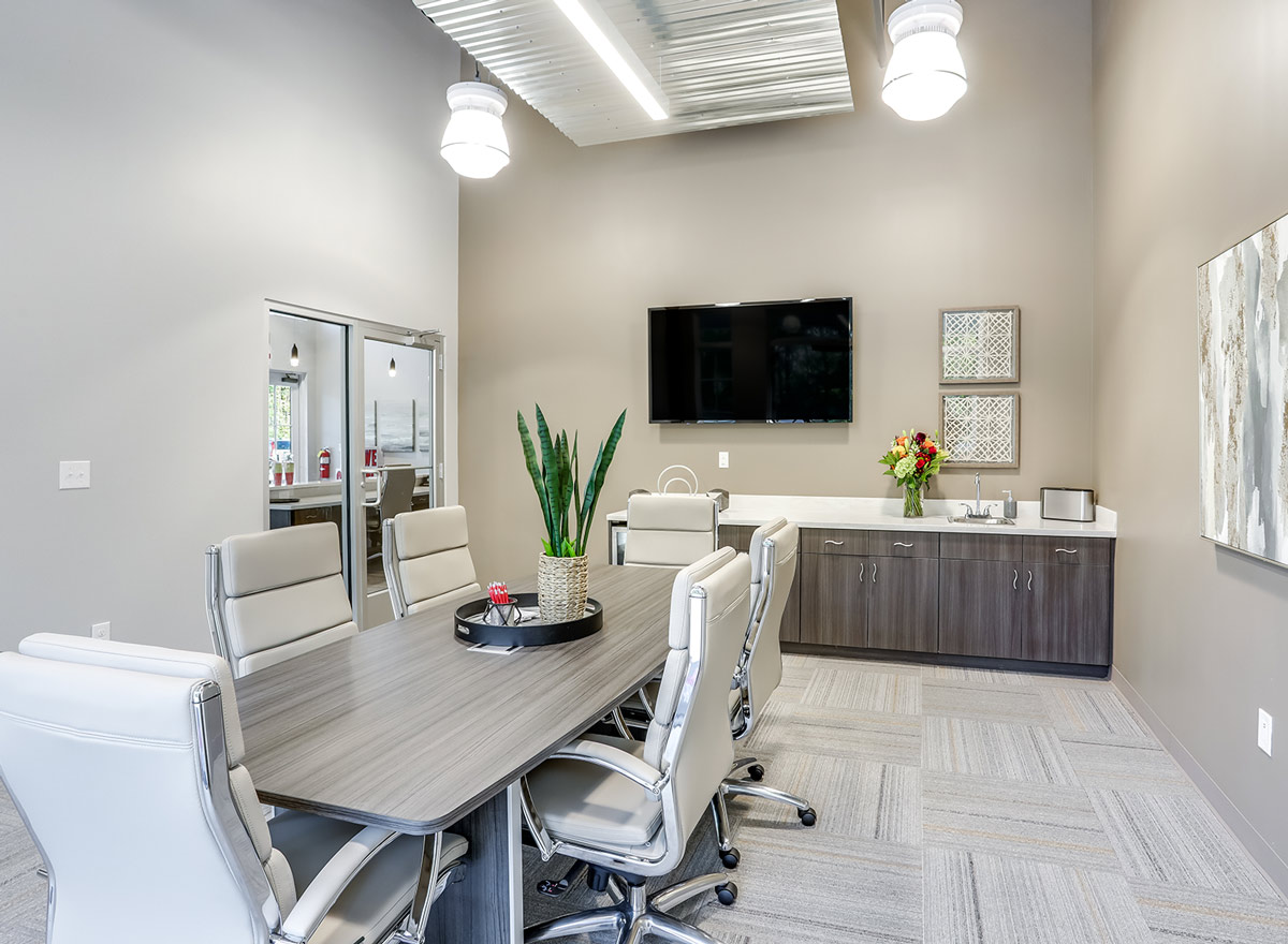 a conference room, featuring a six chaired conference table and a small counter and sink, reserved for tenant use