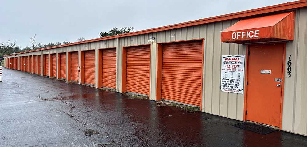 a line of Panama Mini Warehouse units with orange rolling doors
