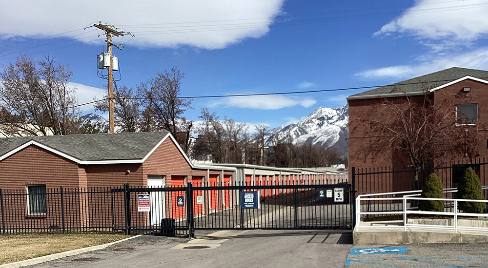view from outside the entrance gate at the orange rolling storage unit doors of the Prime Storage facility