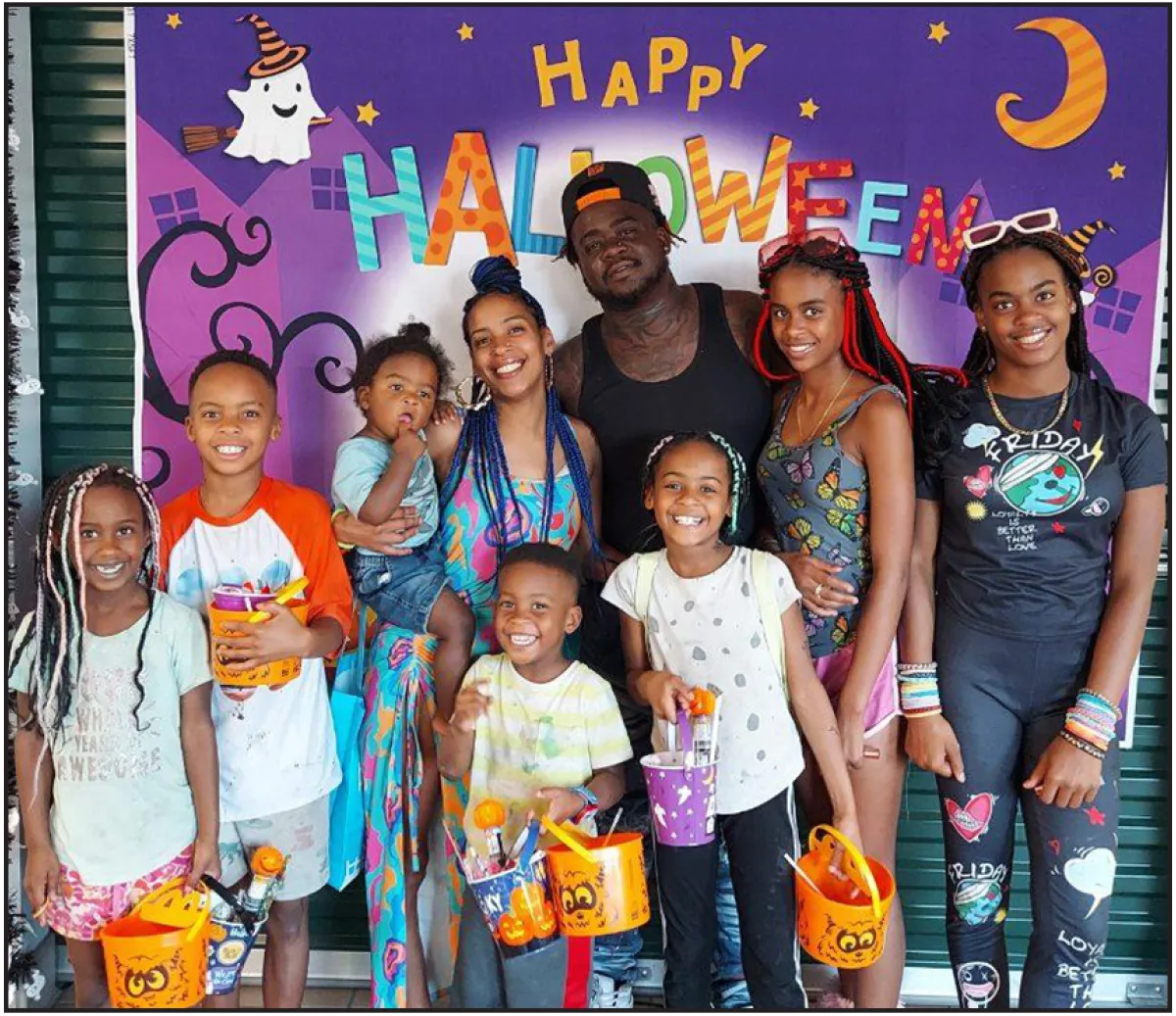 family taking photo in front of Halloween themed backdrop