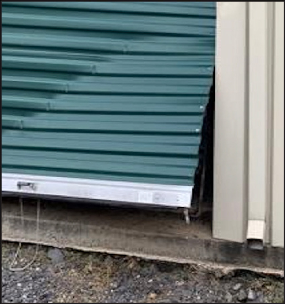 Image 6.2 - Actual break-in photo of door curtain pried open from the bottom bar