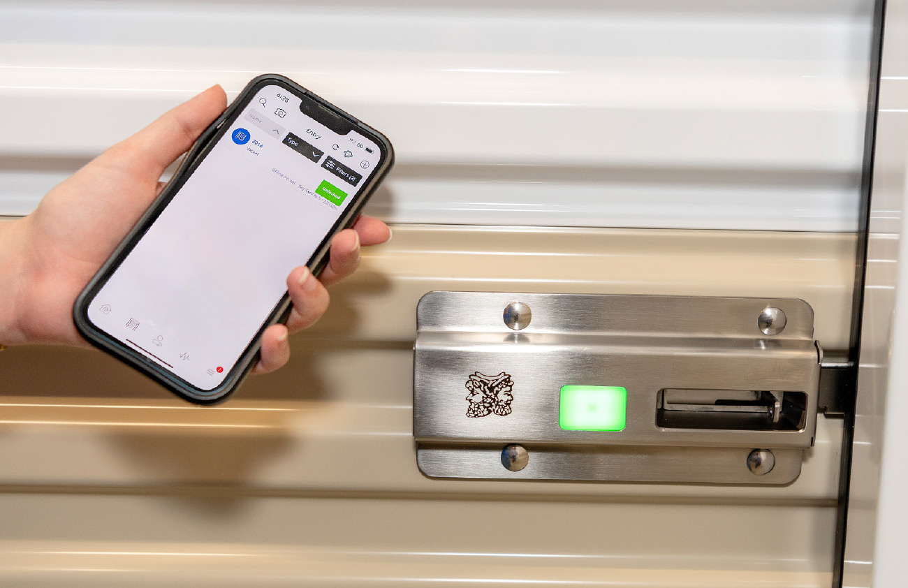 hand holding phone up to storage door lock 