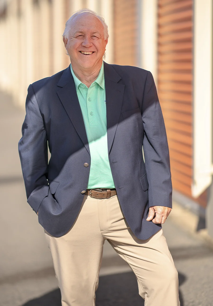 David Dodge wearing business casual attire and posing in front of a storage unit
