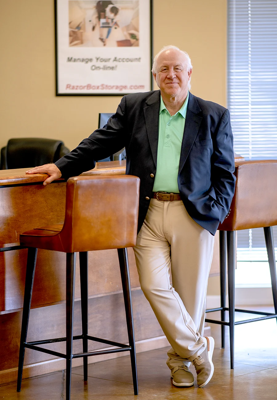 David Dodge wearing business causal attire and posing at a reception desk
