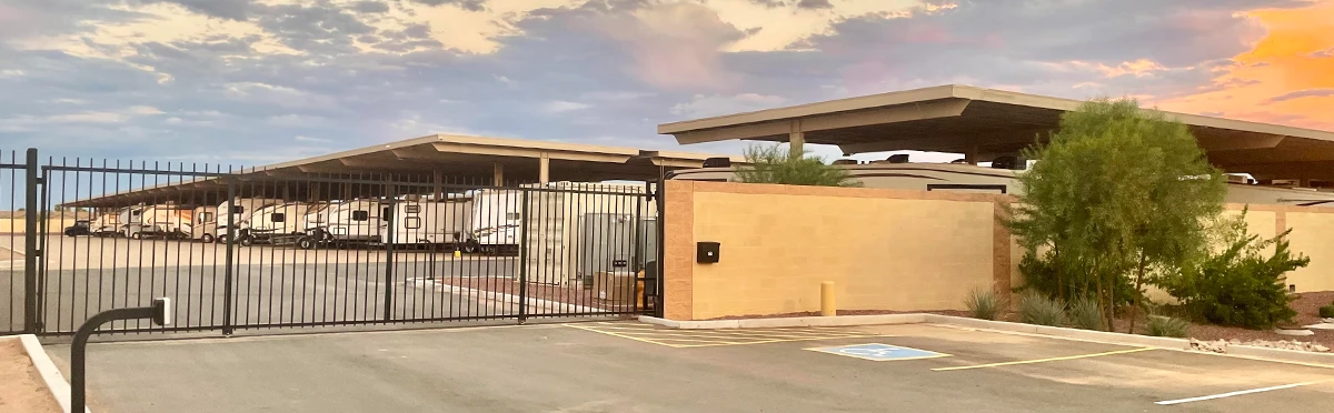 Electronic gate with keypad access at an Ameripark Covered Storage facility in Arizona, showing rows of covered RV storage.