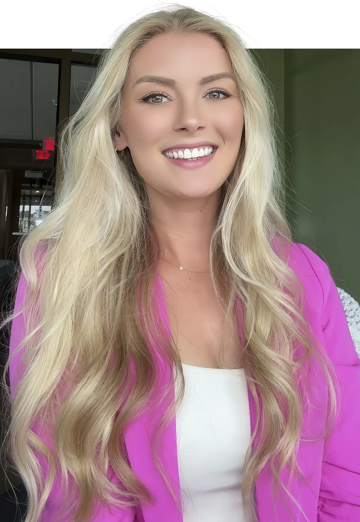 Courtney Cox wearing a  pink blazer and smiling 