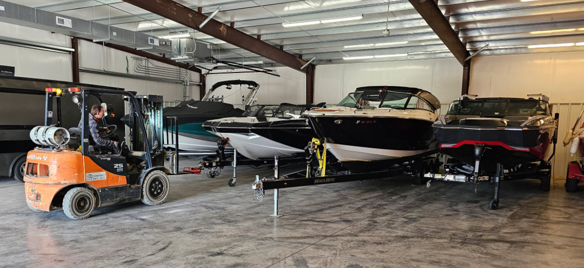 This image shows the interior of a large, covered storage space designed for vehicles and marine craft.