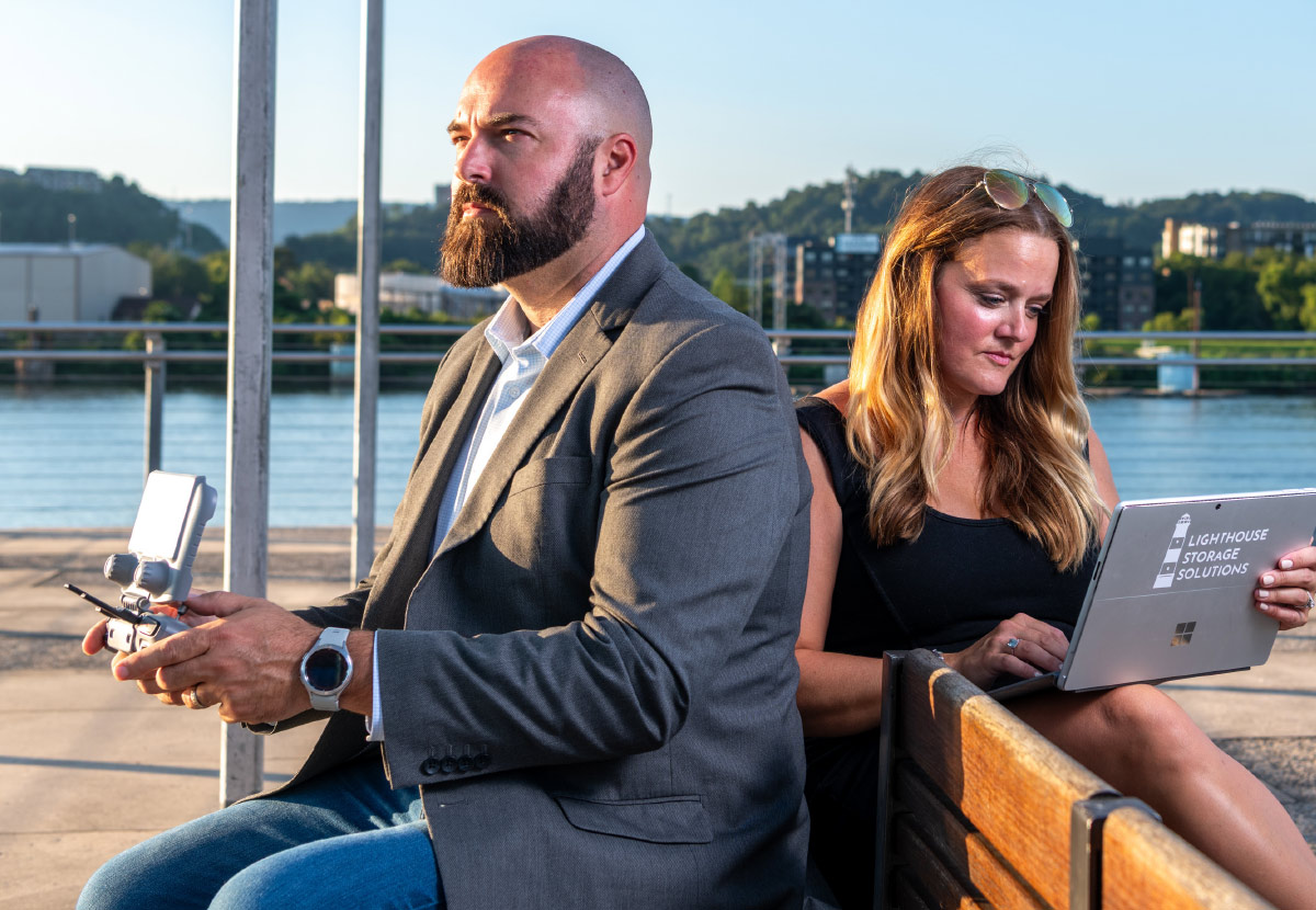 The Huffs with their tools of the trade sitting at bench alongside water