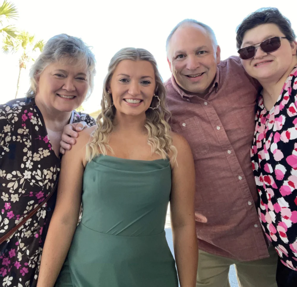 Family photo with four people standing outdoors