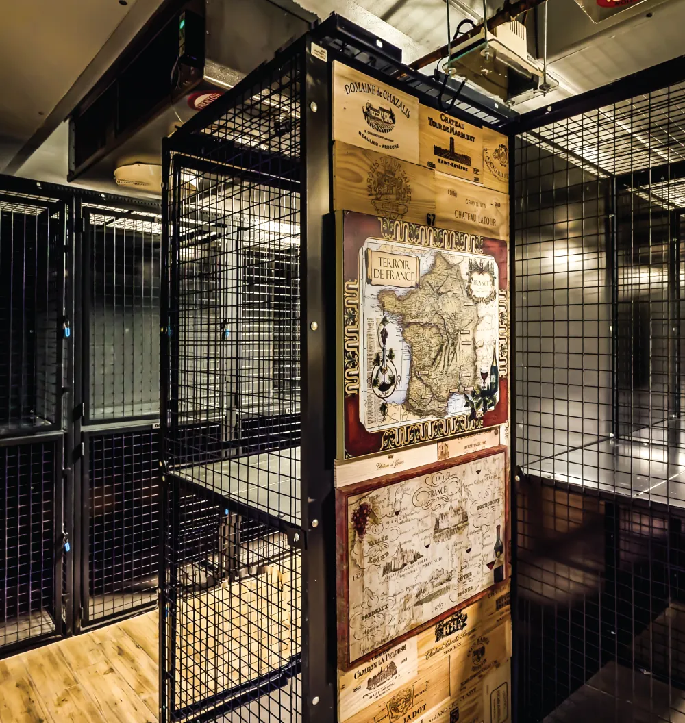 Metal mesh cages with decorative maps on a wooden floor.
