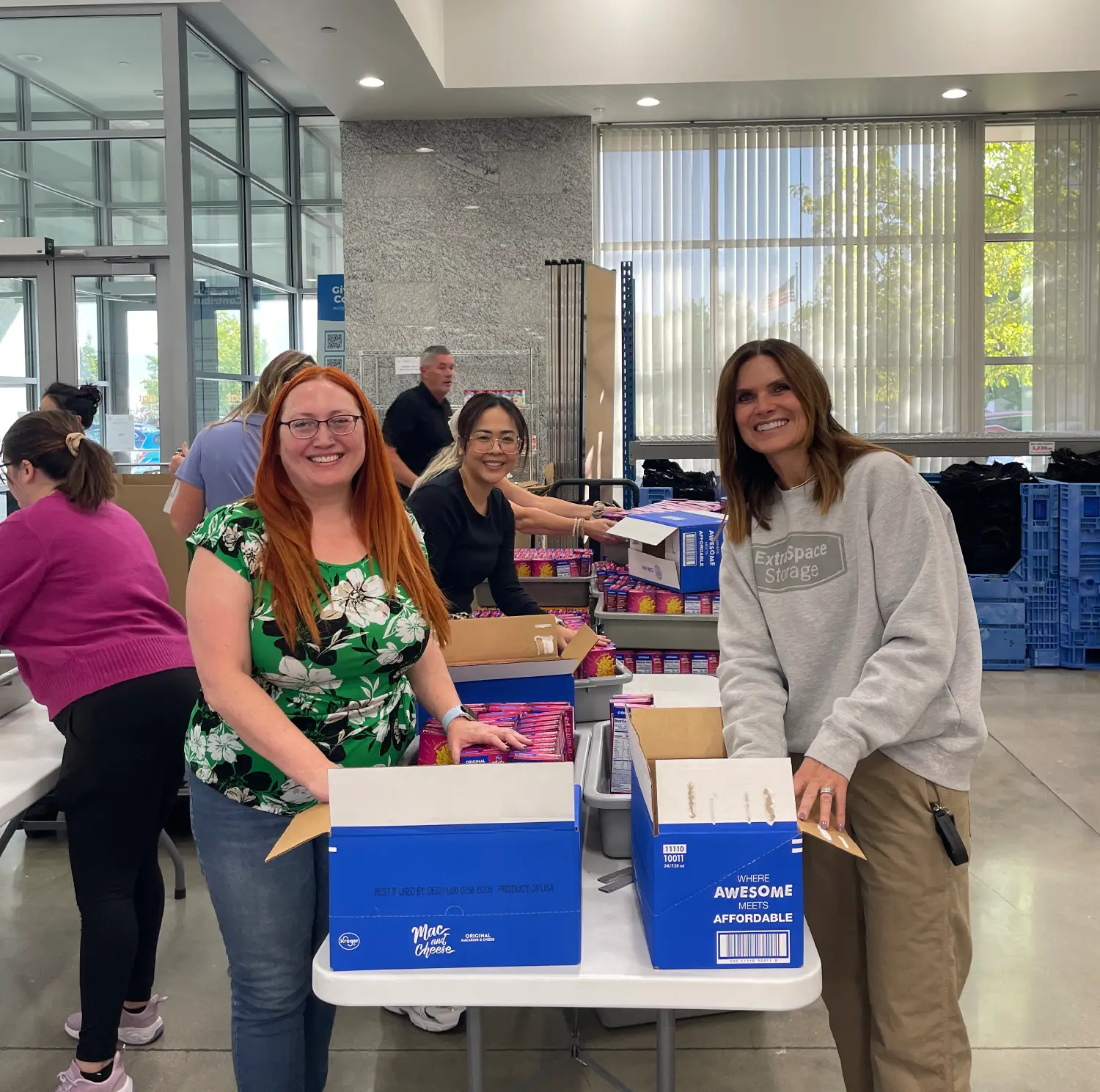 two women smiling and unpacking a box