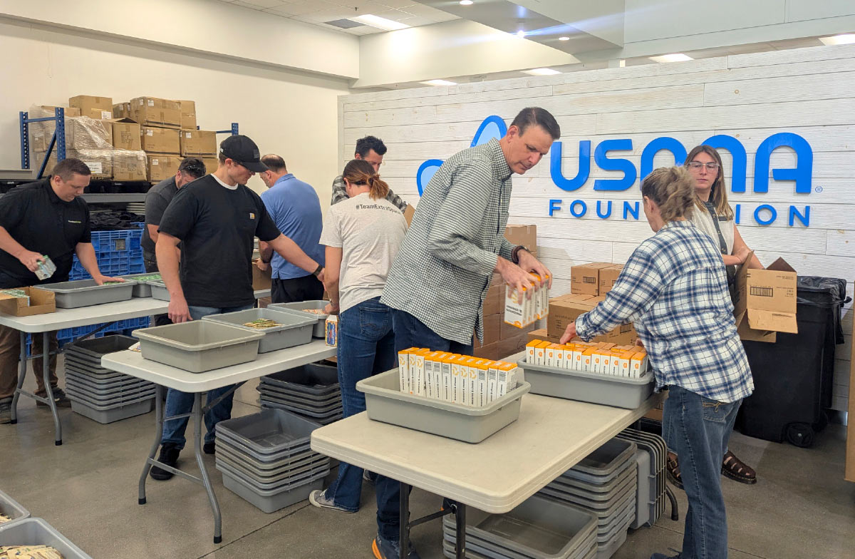 volunteers packing weekend backpacks in warehouse 