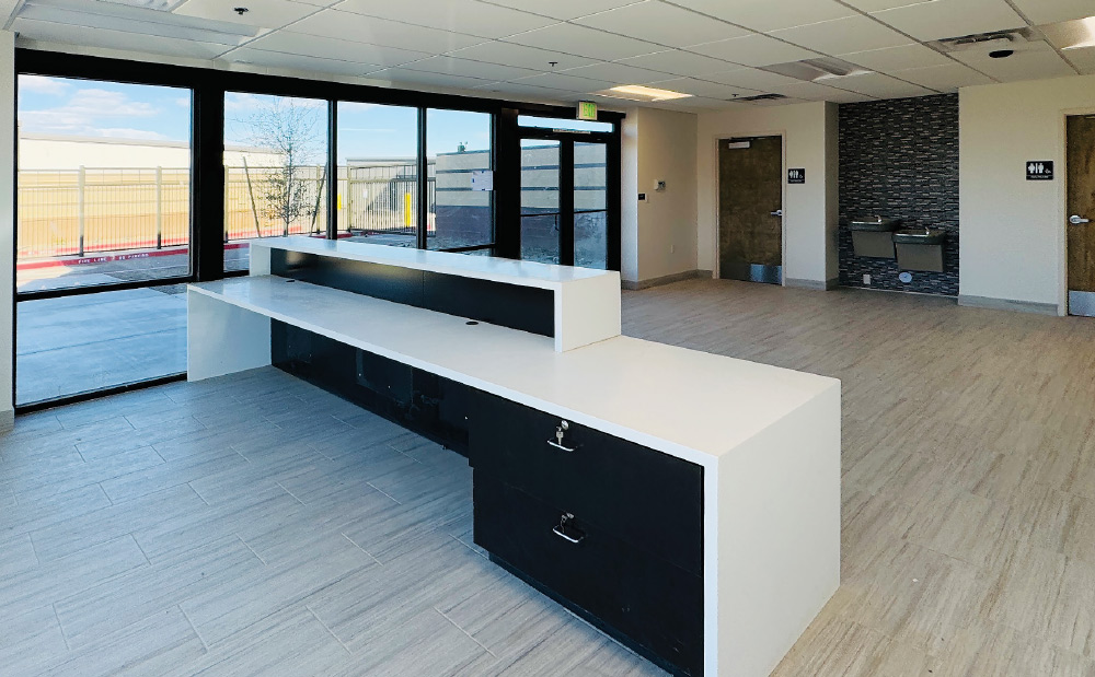 Storelocal Storage facility office with a white counter, light tile floor, and large windows.