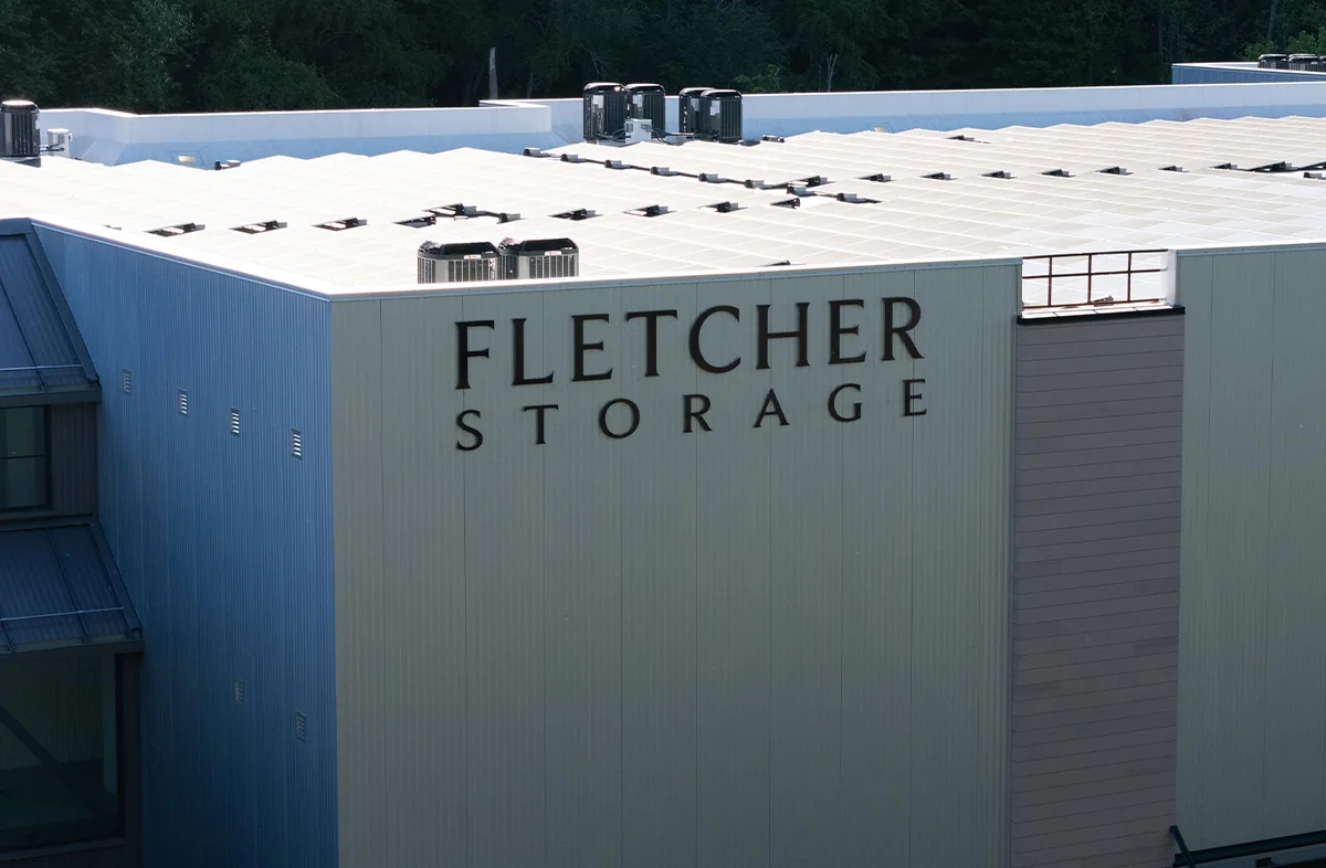 Aerial or high-angle view of the Fletcher Storage commercial building exterior with white siding and rooftop HVAC units.