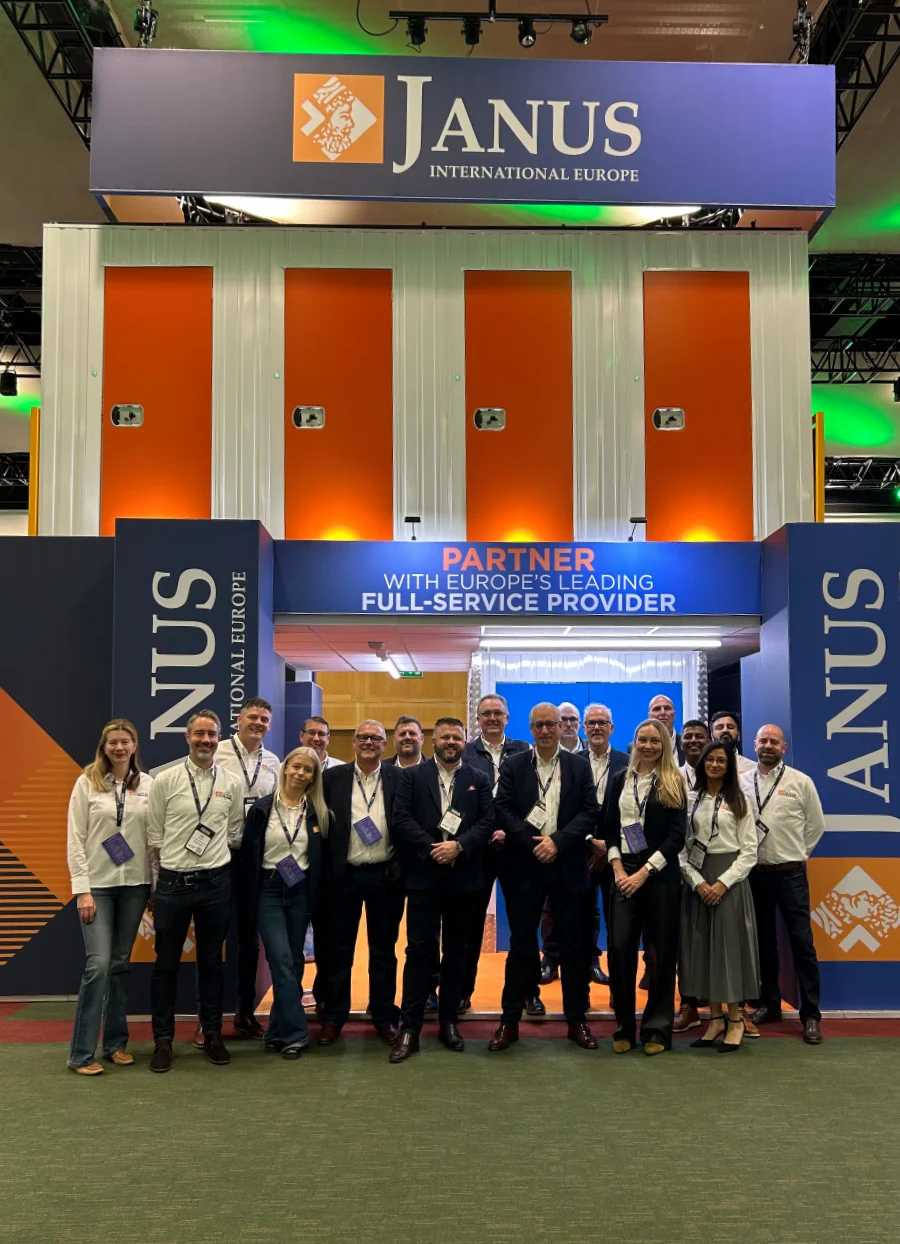 A large group of professional staff standing under a 'Partner with Europe's Leading Full-Service Provider' sign at a self-storage industry convention.