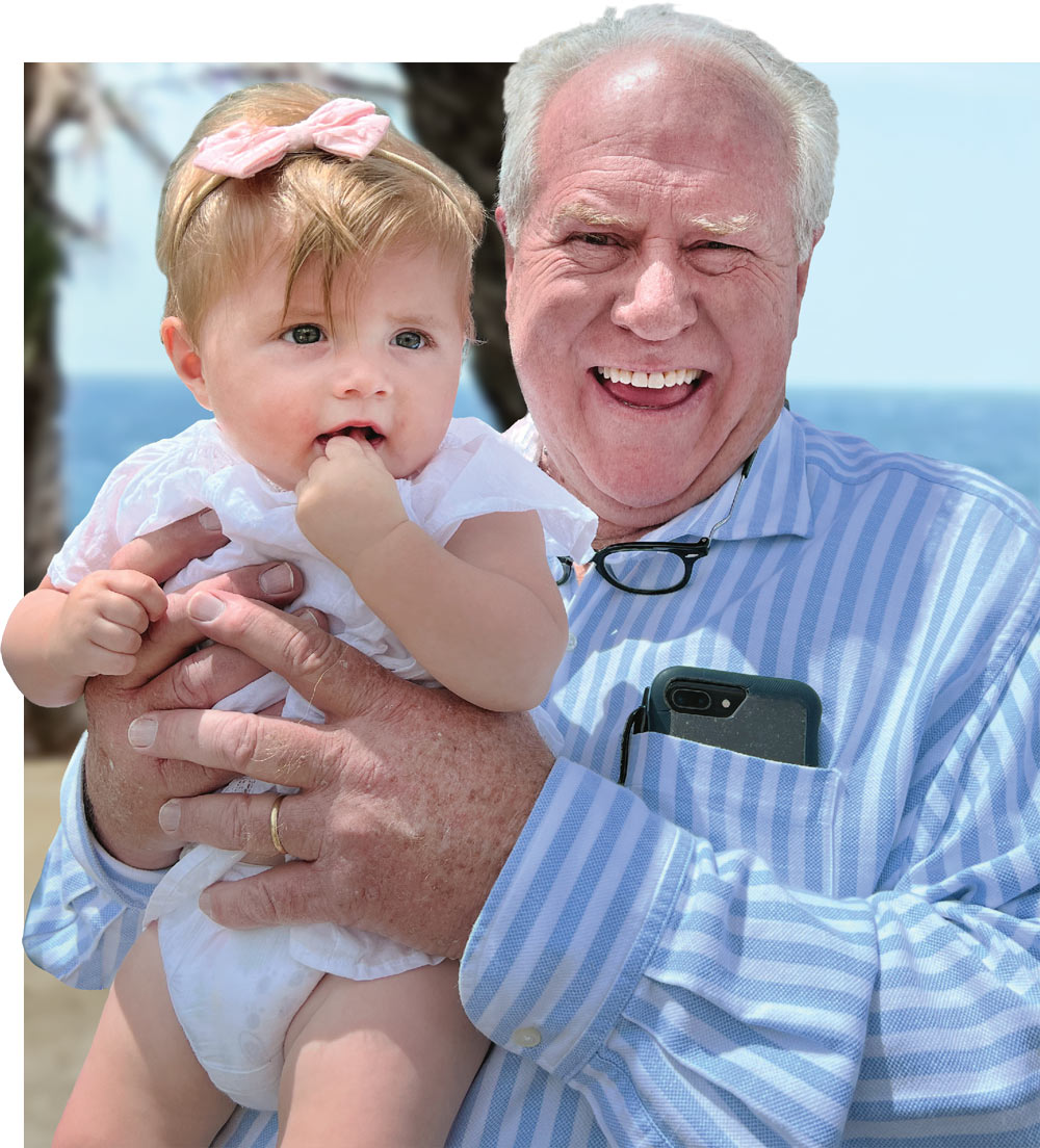 Man holding a baby at the beach.
