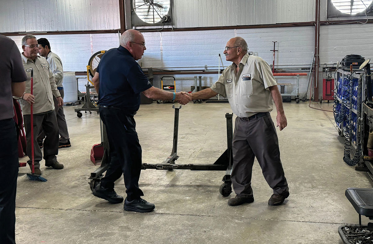 Joe Shoen shakes hands with a U-Haul employee