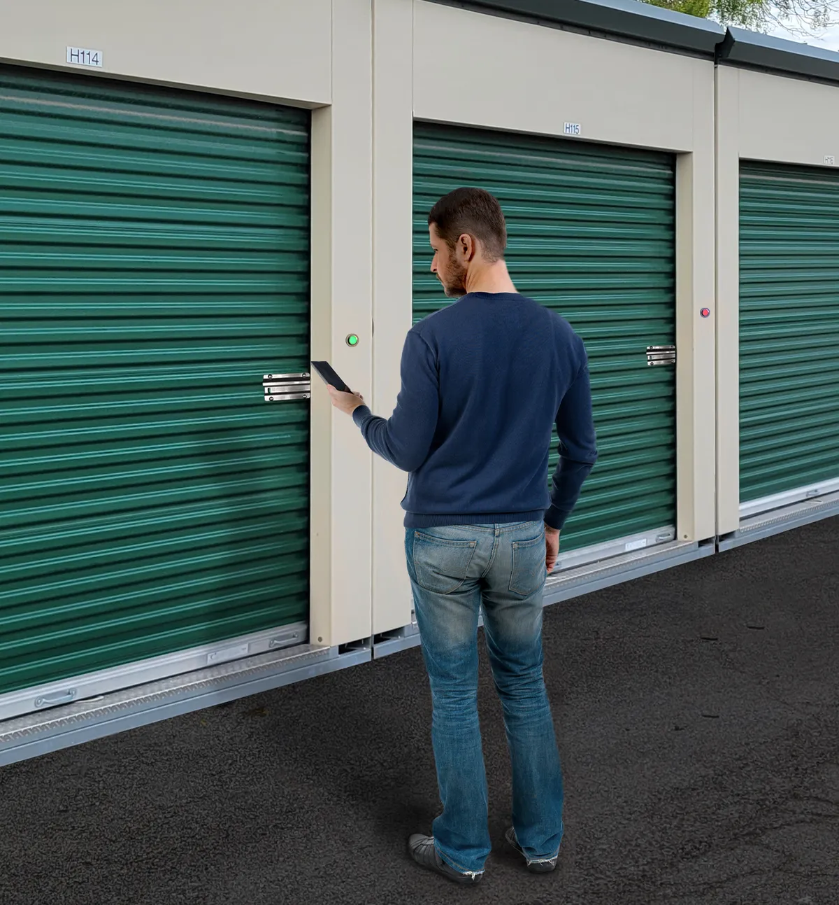 A man using a smartphone app to wirelessly unlock a green roll-up storage unit door equipped with a Noke Smart Entry electronic lock and a glowing green status indicator