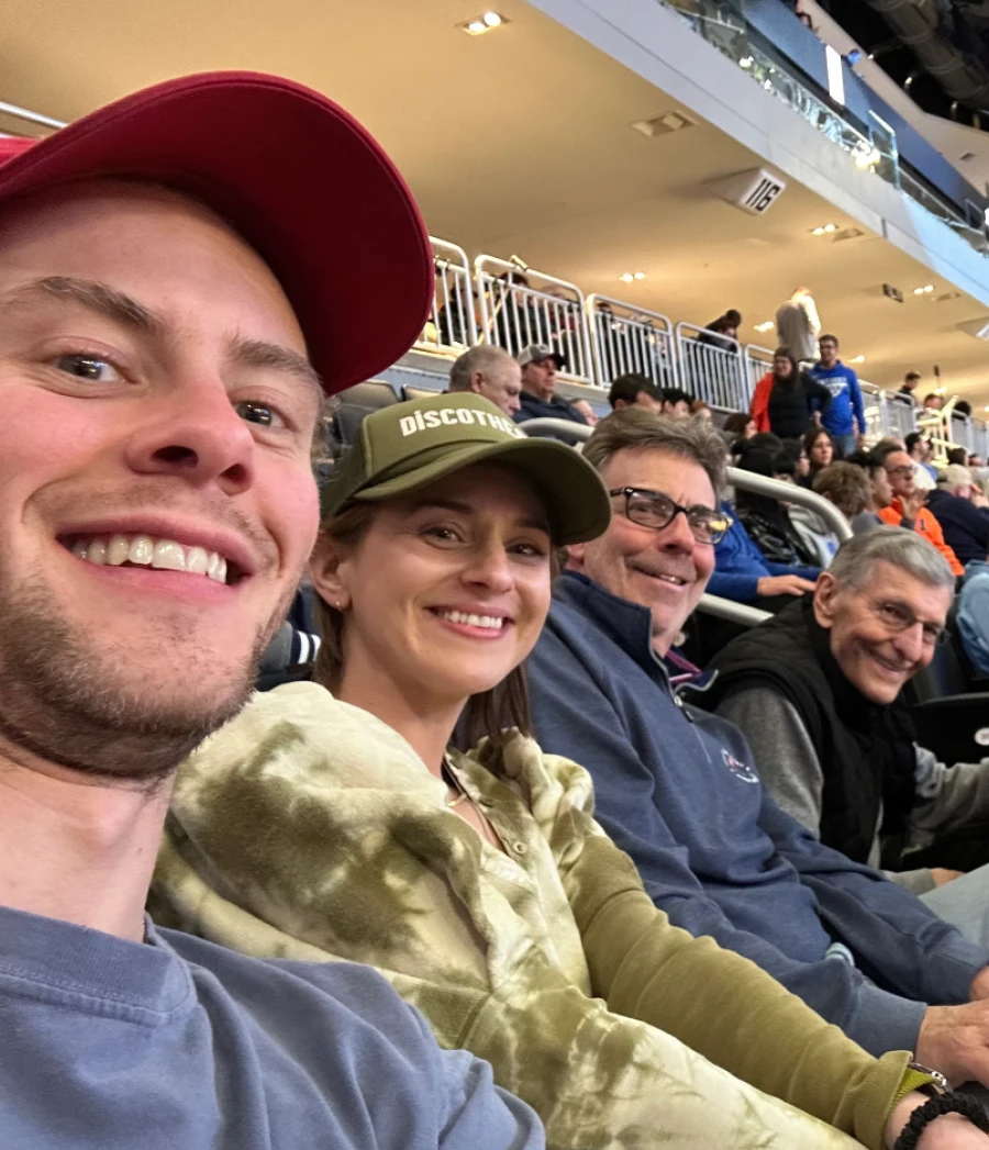Adam Karnes at a basketball game with his wife "Cat," father Rick, and Uncle Bill