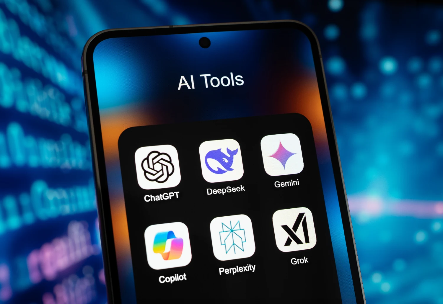 A close-up of a smartphone screen displaying a folder titled "AI Tools" with icons for popular Large Language Models including ChatGPT, DeepSeek, Gemini, Copilot, Perplexity, and Grok against a bokeh blue digital background