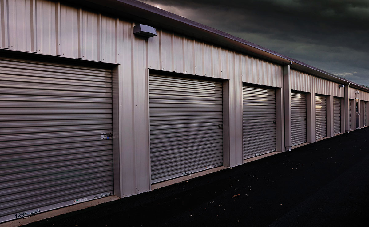 A row of metal self-storage units with closed rolling doors