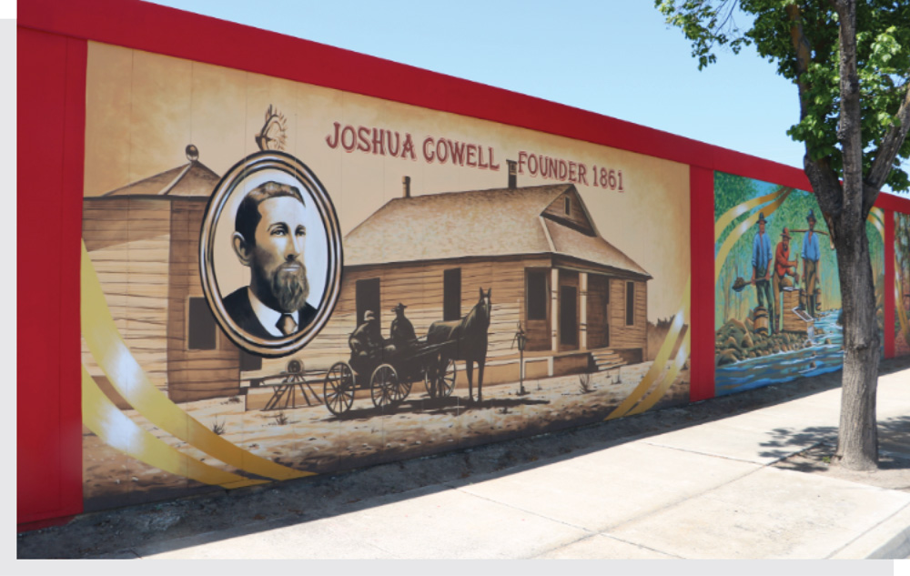 A detailed section of a historic wall mural reading "Joshua Cowell, Founder 1861" with a portrait illustration.