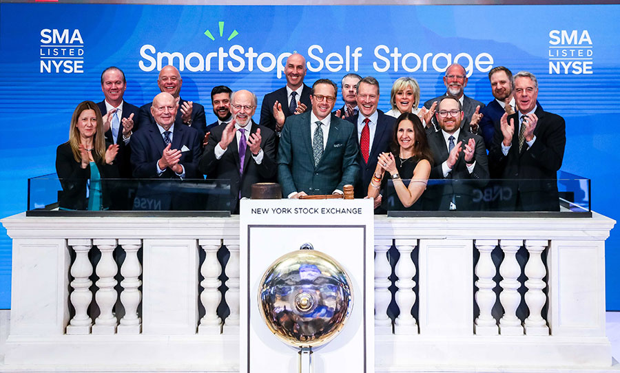 A group of executives applauding at the New York Stock Exchange podium for SmartStop Self Storage.