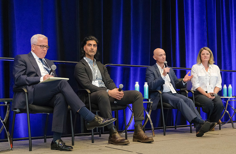 Four professionals sit on a stage participating in a panel discussion