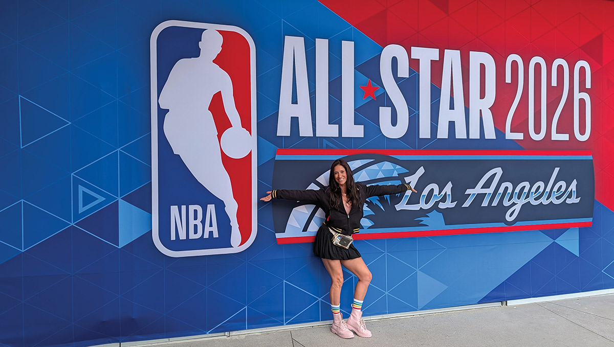 Renee Tulve at the 2026 NBA All Star game in L.A. standing in front of a massive NBA All Star 2026 Los Angeles logo promotional banner wall