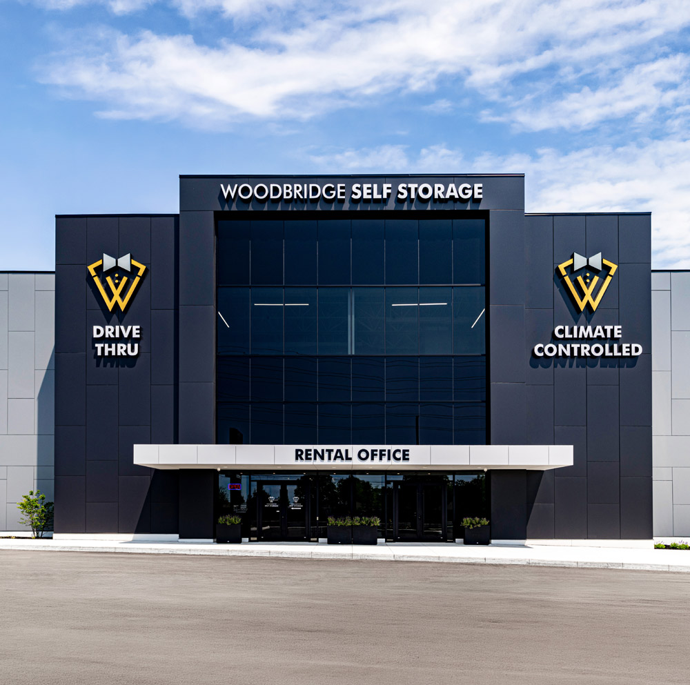 The modern exterior of a Woodbridge Self Storage building with "Drive Thru" and "Climate Controlled" signs.