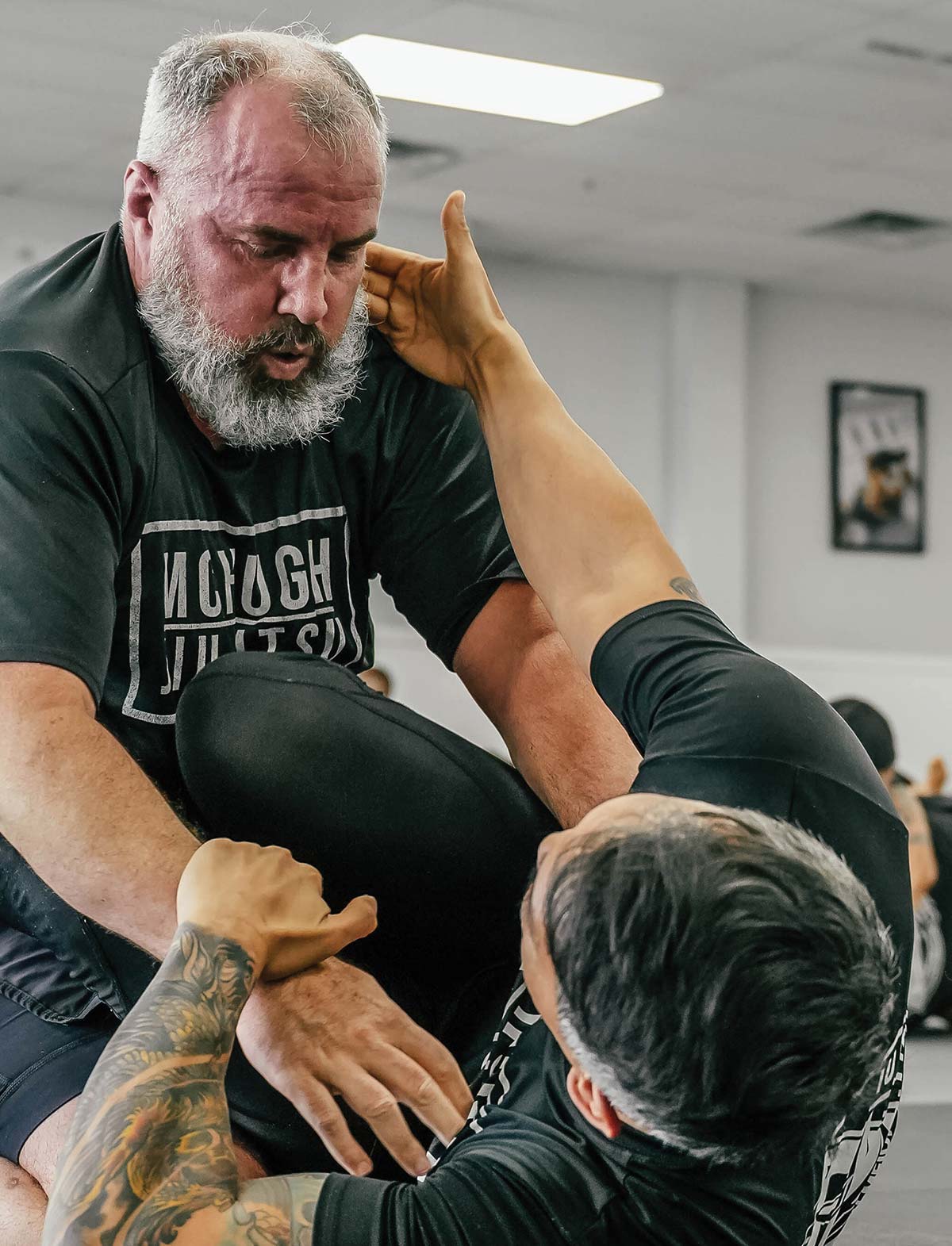 Thaddeus Campbell engaged in a jiu-jitsu grappling match practicing his moves against another man inside a training facility